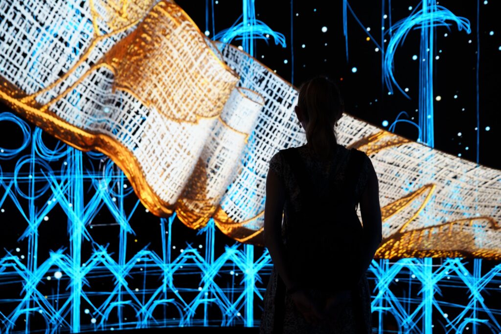 Silhouette of young women in front of abstract display